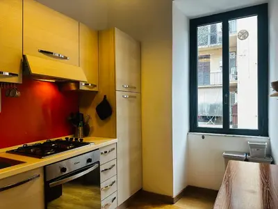 a kitchen with a stove top oven next to a window at Little Colosseum Gem in Rome