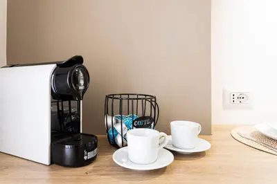 two coffee cups on a counter next to a coffee maker at Vacanze romane - Domus chic Trastevere - Marconi by Hôtea in Rome