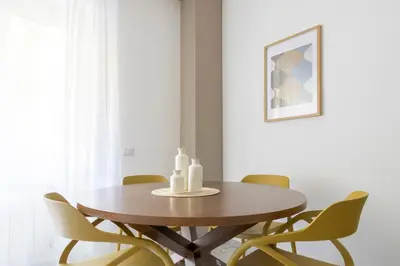 a dining room with a wooden table and chairs at Vacanze romane - Domus chic Trastevere - Marconi by Hôtea in Rome
