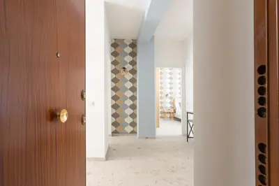 a hallway with a door and a room with white walls at Vacanze romane - Domus chic Trastevere - Marconi by Hôtea in Rome