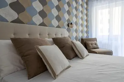 a bedroom with a large white bed and a chair at Vacanze romane - Domus chic Trastevere - Marconi by Hôtea in Rome