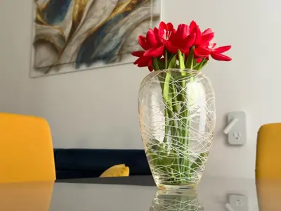 a vase with red flowers sitting on a table at King Vatican Suite in Rome