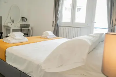 a white bed with towels on top of it at Salotto Tuscolano in Rome