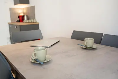 two coffee cups sitting on a table with a laptop at Salotto Tuscolano in Rome