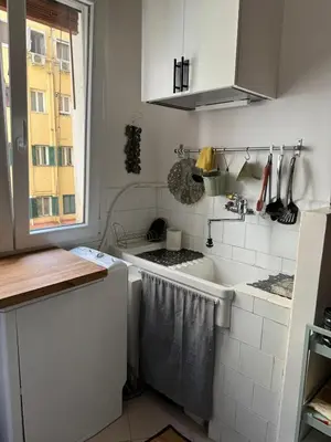 a white kitchen with a sink and a window at Appartamento Corso Trieste in Rome