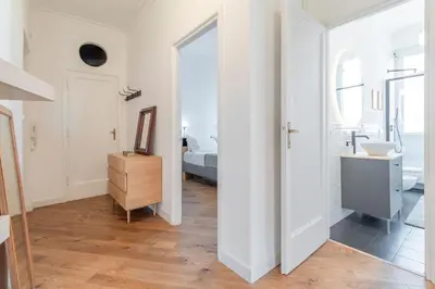 a white bathroom with a sink and a bedroom at AureaLiving - Satrico Cozy Apartment fast WIFI and Air Conditioning in Rome