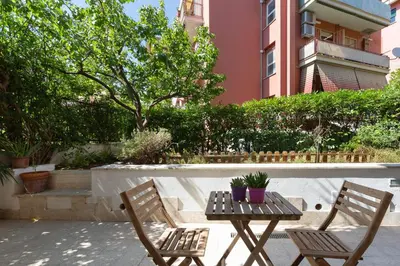 two chairs and a table with plants on a patio at La Buganvillea locazione turistica in Rome