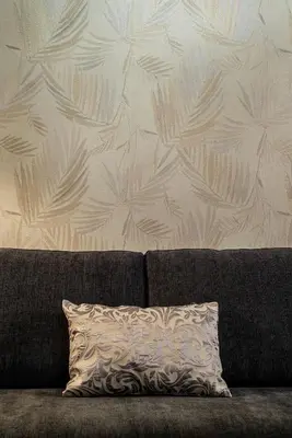 a pillow on a couch in front of a wall at Trevi Garden Suite in Rome