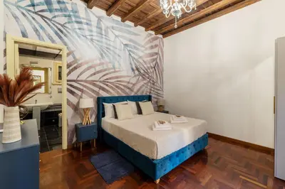 a bedroom with a blue bed and a mirror at Trevi Garden Suite in Rome