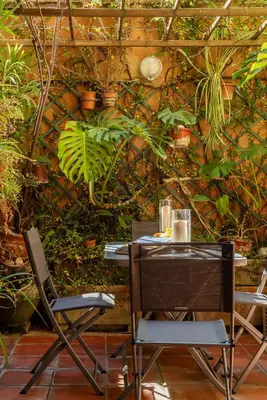 a table and chairs in front of a wall with plants at Trevi Garden Suite in Rome