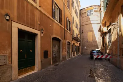 an alley with a green door on a building at Trevi Garden Suite in Rome