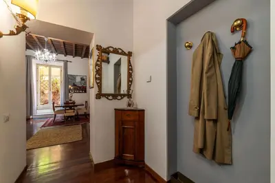a hallway with a mirror and a coat hanging on a wall at Trevi Garden Suite in Rome