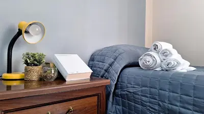 a bedroom with a blue bed and a table with a lamp at Appartamento via Caneva - Tiburtina in Rome
