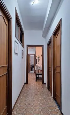 a hallway with two doors and a room with a table at Appartamento via Caneva - Tiburtina in Rome
