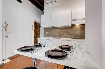 a white kitchen with glasses and plates on a counter at New Spanish Square - RomeDreamHome in Rome