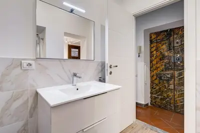 a white bathroom with a sink and a mirror at New Spanish Square - RomeDreamHome in Rome