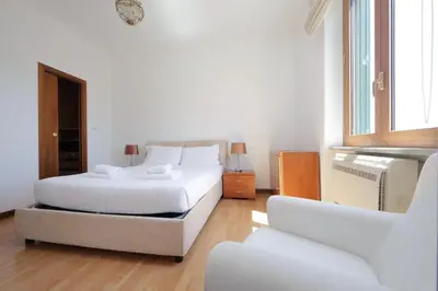 a white bedroom with a bed and a couch at Stazione Trastevere 3BR Flat by Flatinrome in Rome