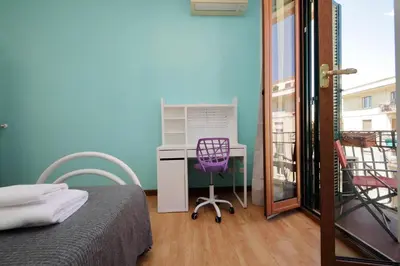 a bedroom with a desk and a purple chair at Stazione Trastevere 3BR Flat by Flatinrome in Rome