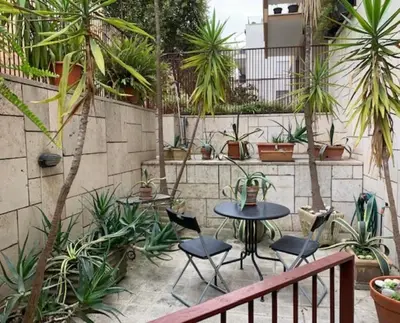 a patio with a table and chairs and plants at Orchidea Bianca Home in Rome
