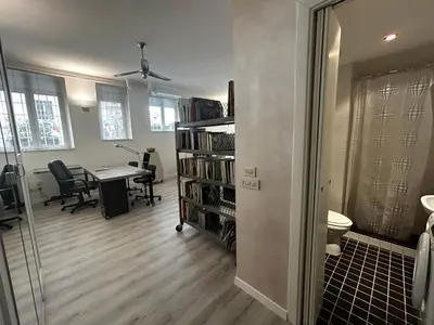 an office with a desk and a book shelf with books at Orchidea Bianca Home in Rome