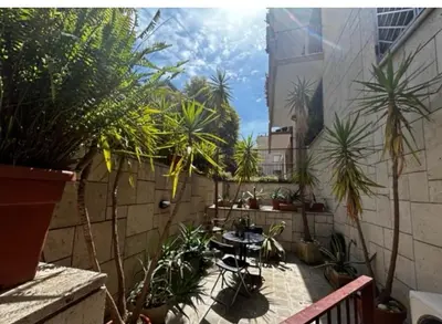 a patio with palm trees and a table in a courtyard at Orchidea Bianca Home in Rome