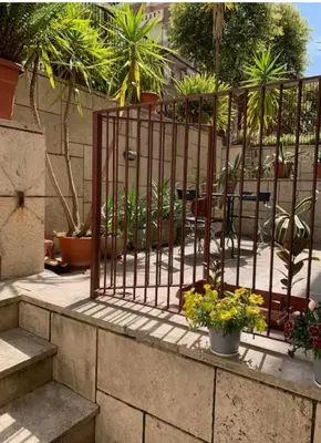 a fence with some plants and some plants at Orchidea Bianca Home in Rome