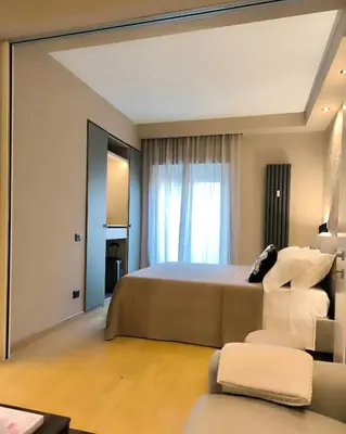 a bedroom with a large bed and a large window at CEMMA luxury apartment in Rome