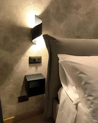 a bedroom with a bed and a lamp on the wall at CEMMA luxury apartment in Rome