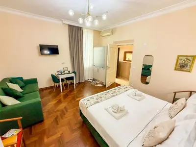 a hotel room with a bed and a green couch at Alloggio vicino Termini La Casetta in Rome