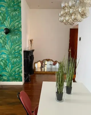 two plants sitting on a table in a room with a chandelier at Volupta' s house Trastevere Station in Rome