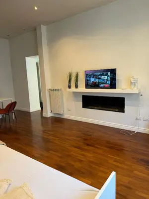 a living room with a flat screen tv on a wall at Volupta' s house Trastevere Station in Rome