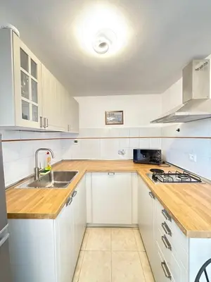 a white kitchen with white cabinets and a sink at Rooftop View St Peter by Dama in Rome