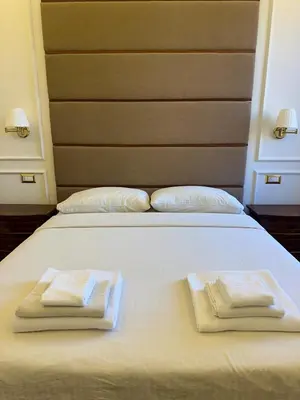 a white bed with two folded towels on it at Dandy Elegance Loft in Rome