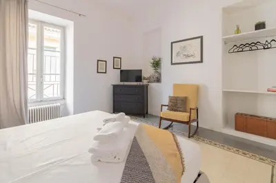 a white bedroom with a bed and a chair at Falstaff in Rome