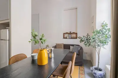 a dining room table with chairs and a yellow vase at Falstaff in Rome