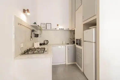 a white kitchen with a stove and a refrigerator at Falstaff in Rome