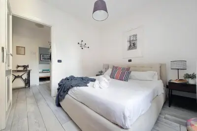 a bedroom with a large white bed and a desk at Fidelio Holiday Home in Rome