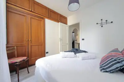 a bedroom with two white beds and a wooden cabinet at Fidelio Holiday Home in Rome