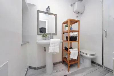 a bathroom with a sink and a toilet and a mirror at Fidelio Holiday Home in Rome