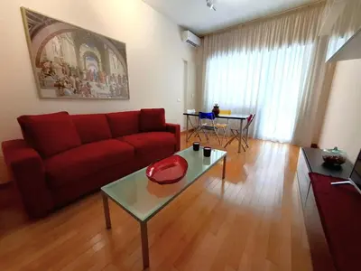 a living room with a red couch and a table at Sophìa, City Retreat near Vatican in Rome