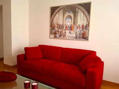 a red couch in a room with a painting on the wall at Sophìa, City Retreat near Vatican in Rome
