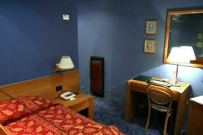 a bedroom with a bed and a desk with a telephone at LH Hotel Andreotti in Rome