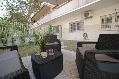 a patio with wicker chairs and a table with a plant at Suites Conca D'Oro, Roma in Rome