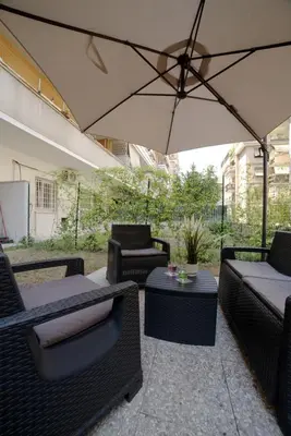 a patio with chairs and tables and an umbrella at Suites Conca D'Oro, Roma in Rome