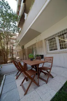 a wooden table and two chairs on a patio at Suites Conca D'Oro, Roma in Rome