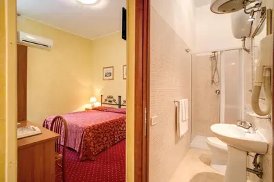 a bathroom with a bed and a toilet and a sink at Monti Guest House - Affittacamere in Rome