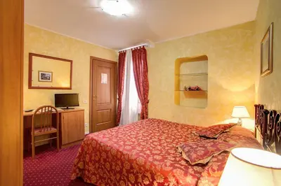 a hotel room with a bed and a desk at Monti Guest House - Affittacamere in Rome