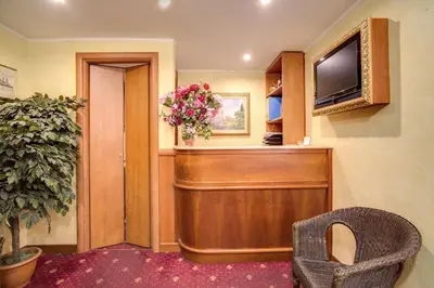 a waiting room with a television and a chair at Monti Guest House - Affittacamere in Rome