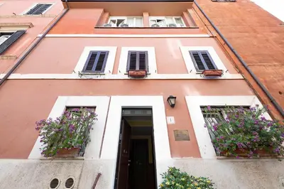 a building with two windows and a door with flowers at Monti Guest House - Affittacamere in Rome