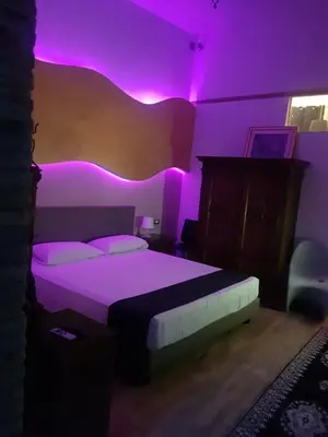 a bedroom with a bed with purple lights on it at Nerva Accommodation Cavour in Rome